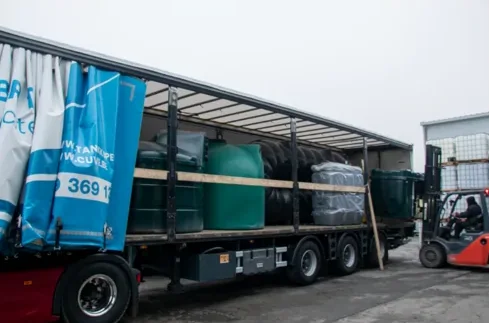 Camion bâché chargé de cuves, prêt à livrer