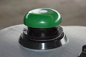 Protection anti-débordement à capuchon vert vissée sur une citerne grise