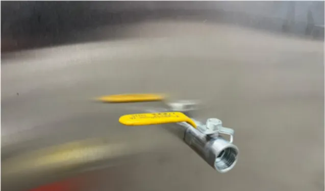 Robinet de vidange à poignée jaune monté sur la paroi d’un bac en inox